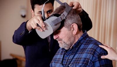 研究人员将虚拟现实头盔戴在成年参与者身上