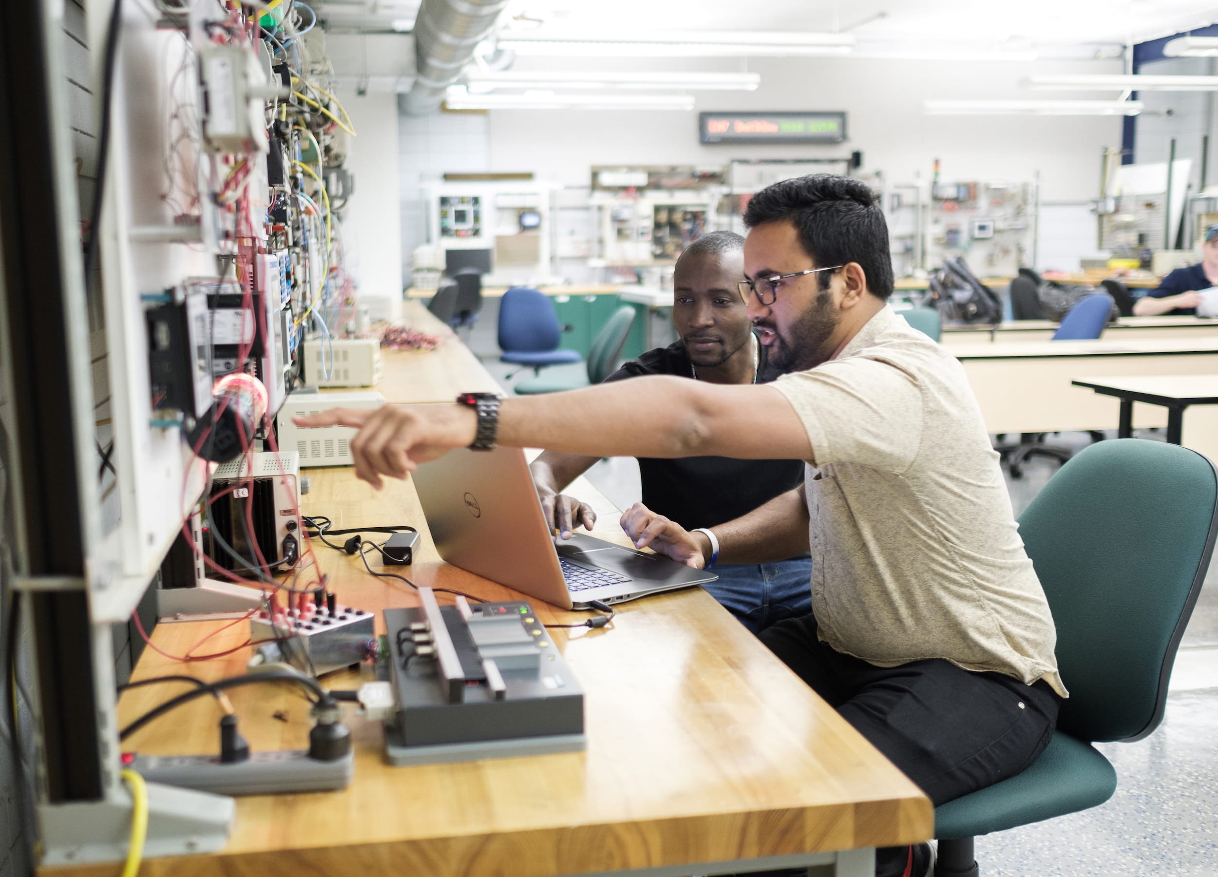 两个电气工程专业的学生坐在一台笔记本电脑前。